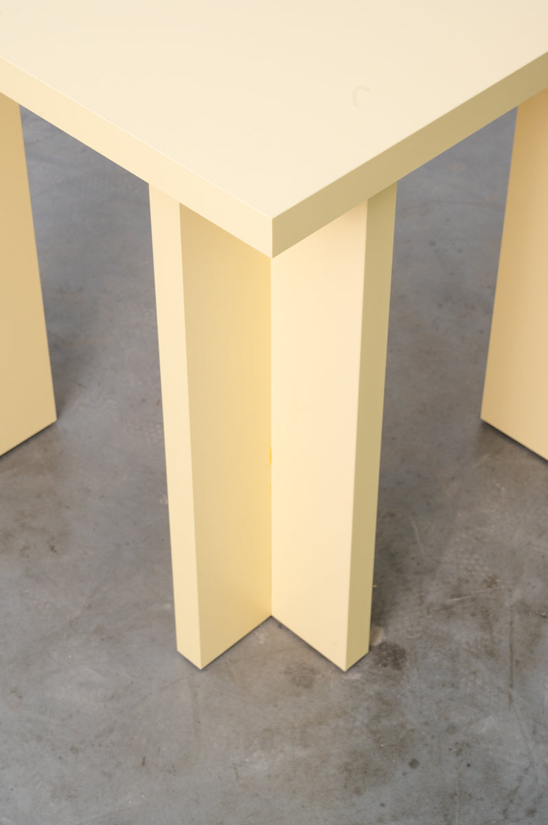Detail of rectangular wooden dining table in butter yellow designed by Bobbie Bahama