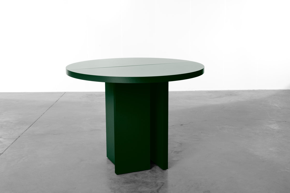 Dark moss green wooden round table designed by Bobbie Bahama