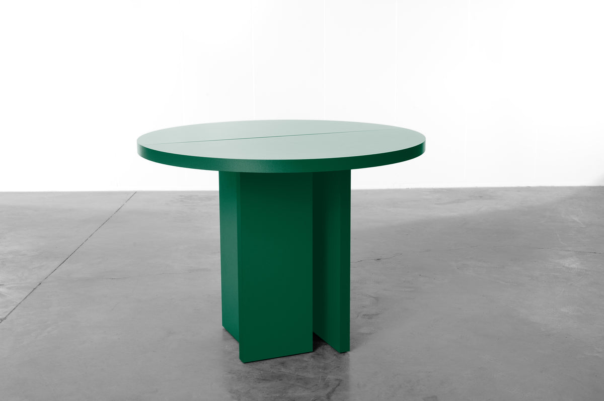 Bright deep green wooden round table designed by Bobbie Bahama