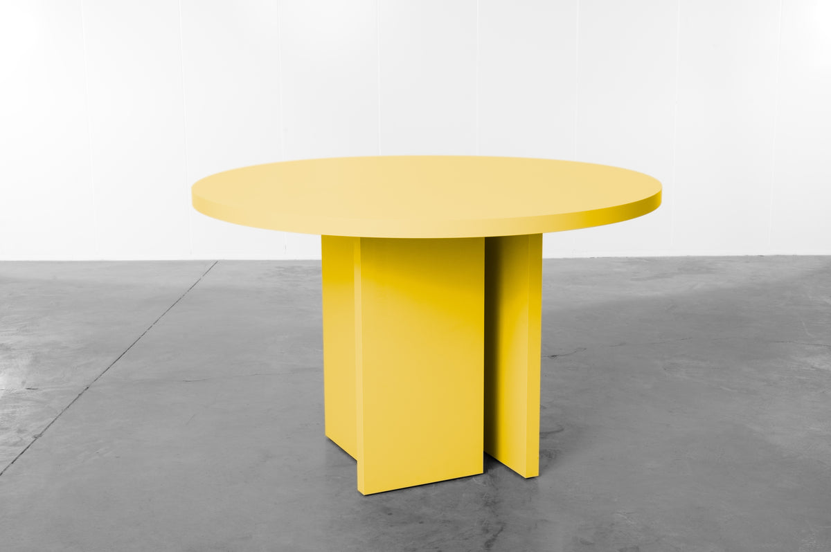 Bright yellow wooden round table designed by Bobbie Bahama