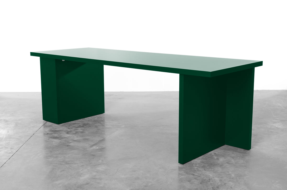 Large rectangular wooden dining table in deep moss green designed by Bobbie Bahama