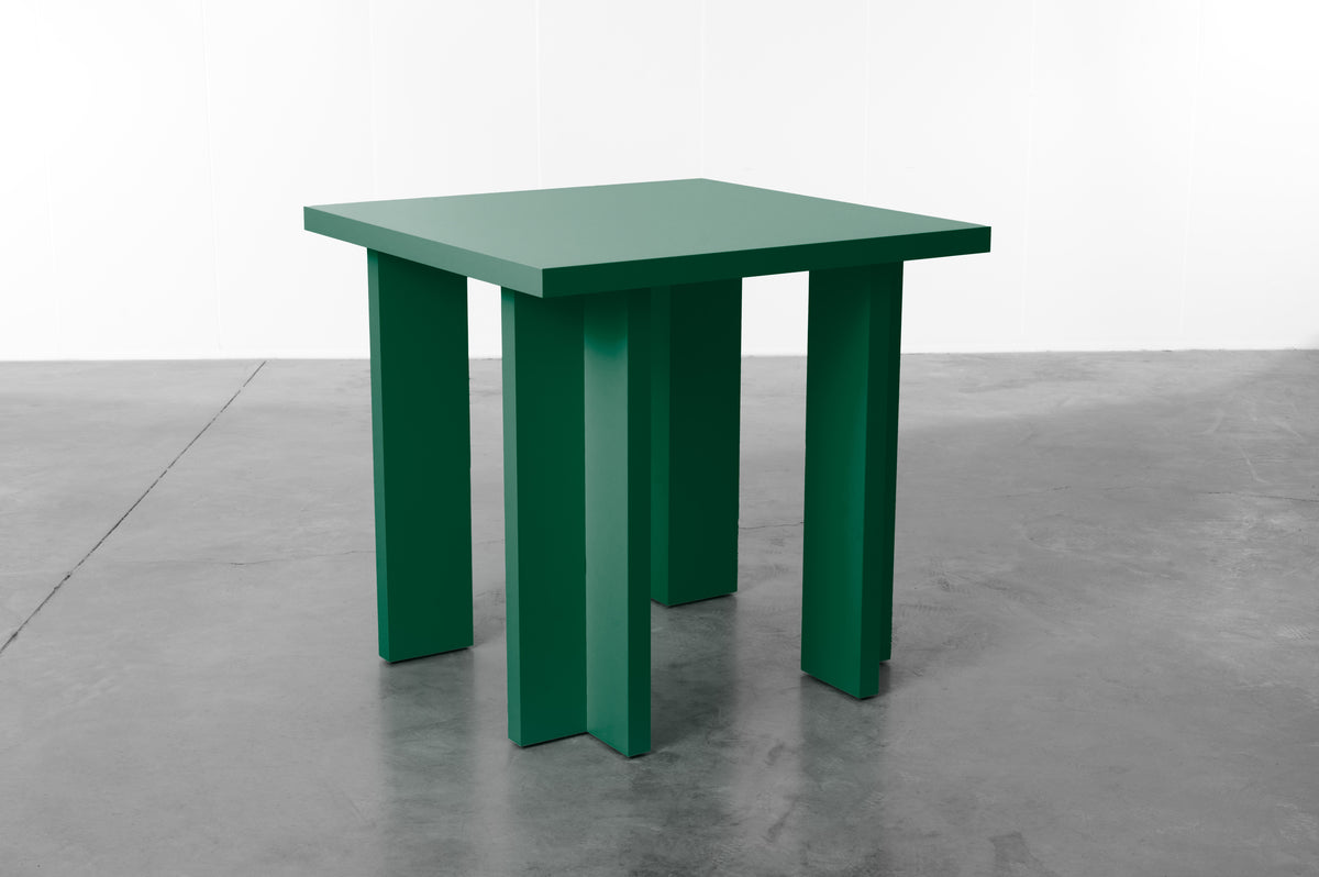 Rectangular wooden dining table in deep forest green designed by Bobbie Bahama